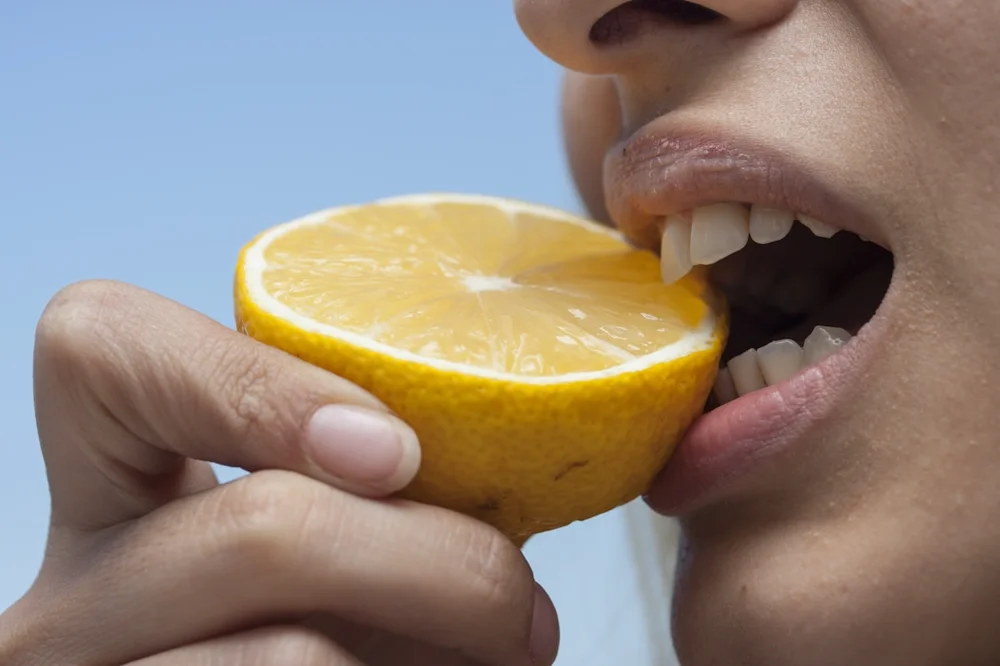 Person eating citrus fruit. Photo by <a href='https://unsplash.com/@enginakyurt'>Engin Akyurt</a> on <a href='https://unsplash.com/photos/b6CCEsofl90'>Unsplash</a>